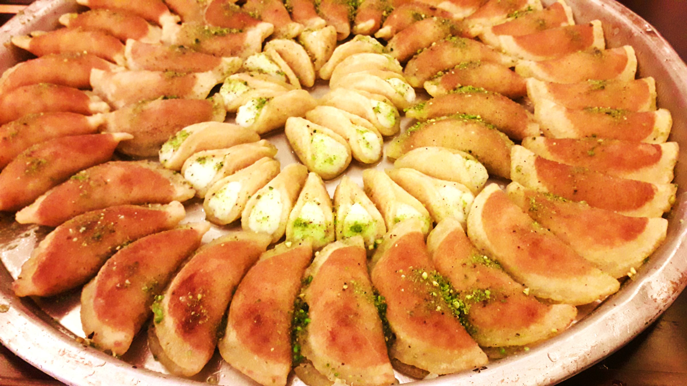 Palestinian Qatayef — Palestine's cherished Ramadan sweet — crisp fried pancakes filled with cinnamon walnuts, dipped in syrup.